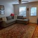 Large family room with wood floors & good natural light. There is a door that leads to the outside storage closet and rear patio. We have added a ceiling fan which is AWESOME! All of our units have great updates including smooth ceilings!